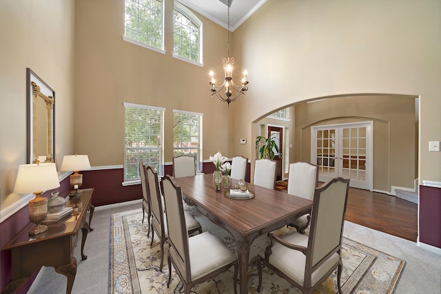 11014 Via Capri Ct, Richmond, TX 77406 - dining space featuring arched walkways, carpet flooring, a high ceiling, a chandelier, and ornamental molding