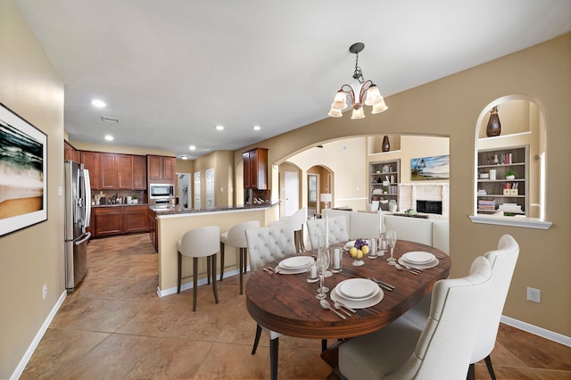 11014 Via Capri Ct, Richmond, TX 77406 - dining room featuring arched walkways, a chandelier, recessed lighting, baseboards, and light tile patterned floors
