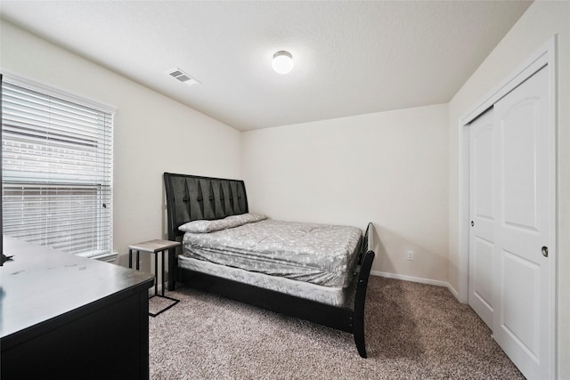 bedroom with light colored carpet, a closet, and baseboards