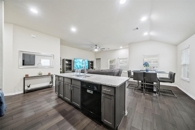 kitchen with black dishwasher, a sink, dark wood-style flooring, ceiling fan, and light stone countertops