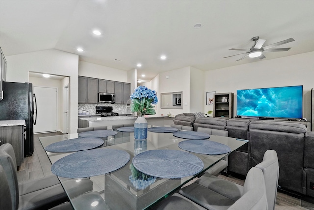 dining area featuring a ceiling fan, light wood-style flooring, lofted ceiling, and recessed lighting