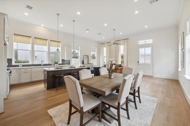 dining room with visible vents, ornamental molding, light wood-style floors, and recessed lighting