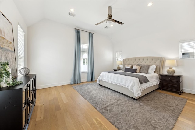 bedroom featuring baseboards, vaulted ceiling, wood finished floors, and visible vents