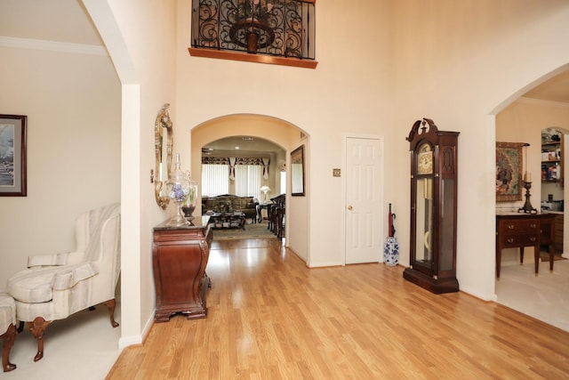 12219 Renaissance Ln, Houston, TX 77071 - foyer entrance with crown molding, arched walkways, baseboards, and light wood-style flooring