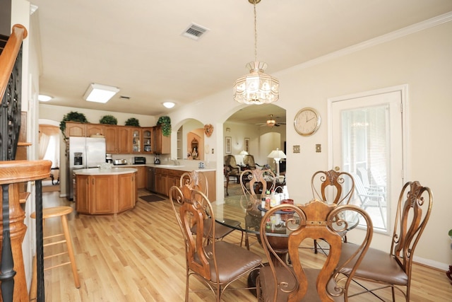 12219 Renaissance Ln, Houston, TX 77071 - dining area with ceiling fan, visible vents, crown molding, arched walkways, and light wood-type flooring