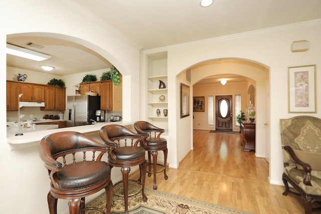 12219 Renaissance Ln, Houston, TX 77071 - interior space with visible vents, crown molding, arched walkways, baseboards, and light wood-style floors