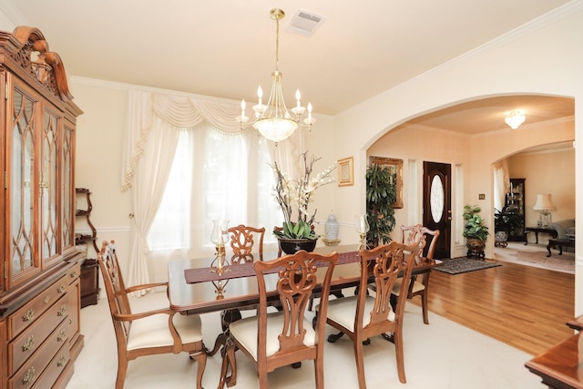 12219 Renaissance Ln, Houston, TX 77071 - dining room with arched walkways, a chandelier, light wood-style flooring, visible vents, and ornamental molding
