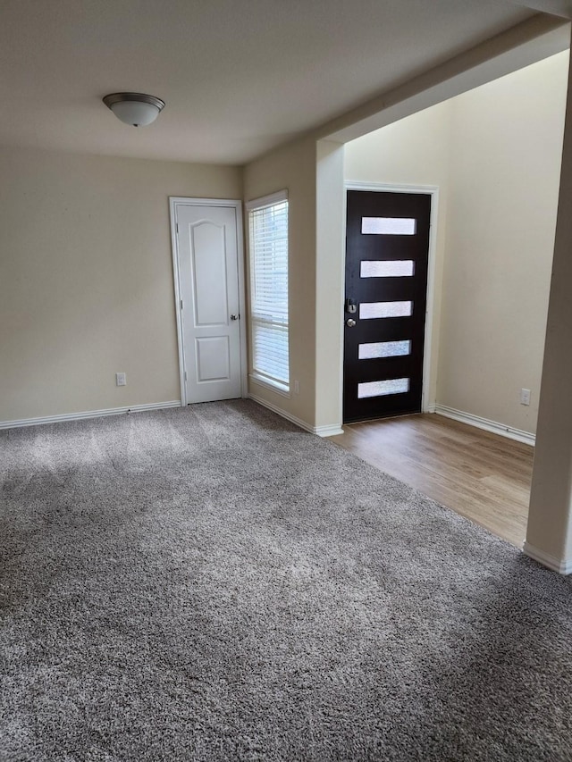 entryway with baseboards and carpet flooring