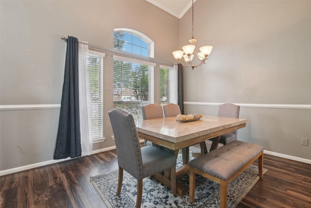 dining area with baseboards, ornamental molding, wood finished floors, and a notable chandelier