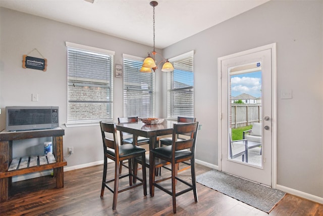 dining space with baseboards and dark wood-style flooring