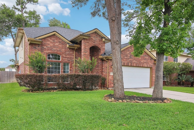 traditional-style house featuring a garage, a front lawn, fence, brick siding, and driveway