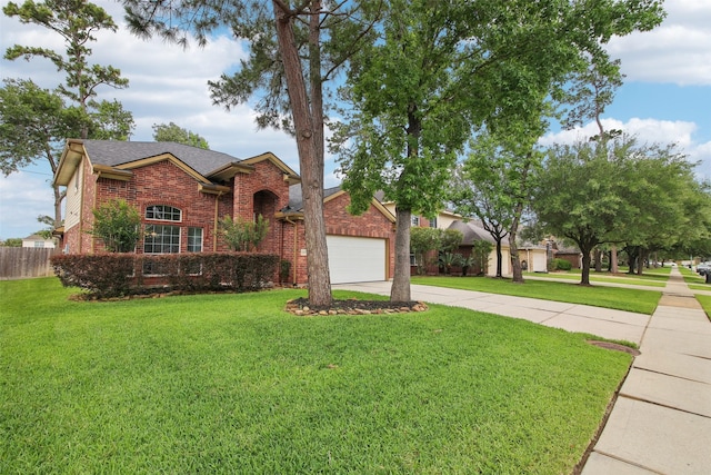 traditional-style house with a garage, brick siding, fence, a front lawn, and concrete driveway