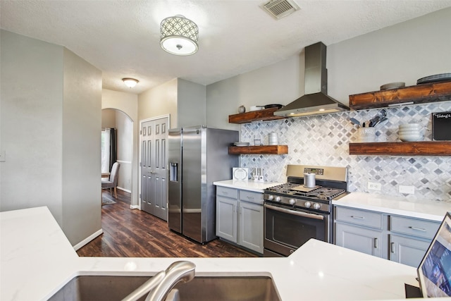 kitchen featuring wall chimney range hood, dark wood-style flooring, visible vents, appliances with stainless steel finishes, and open shelves