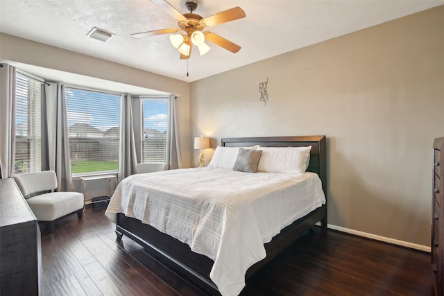 bedroom featuring baseboards, a ceiling fan, hardwood / wood-style floors, and visible vents