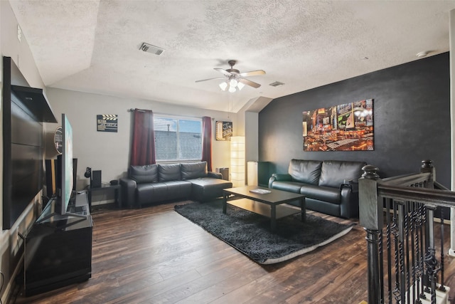 living area featuring ceiling fan, hardwood / wood-style flooring, a textured ceiling, and visible vents