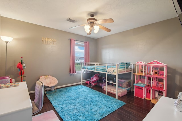 bedroom with baseboards, ceiling fan, wood finished floors, and visible vents