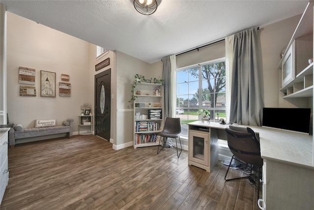 office with built in study area, baseboards, dark wood-style floors, and a textured ceiling