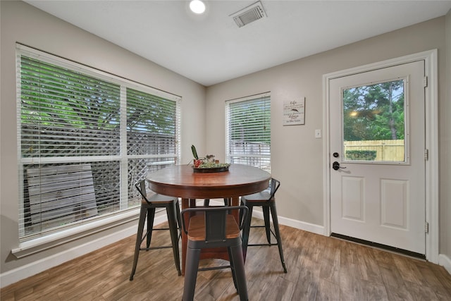 dining space featuring baseboards, visible vents, and wood finished floors