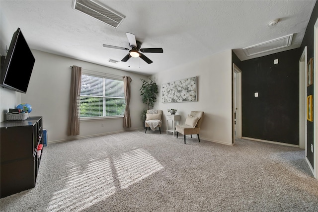 sitting room featuring a ceiling fan, attic access, visible vents, baseboards, and carpet