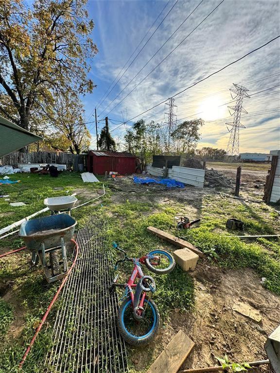 view of yard with fence and a storage unit
