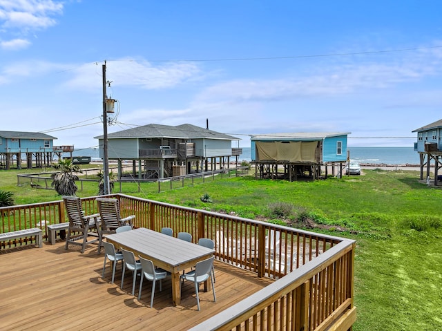deck featuring a water view, fence, a yard, and outdoor dining space