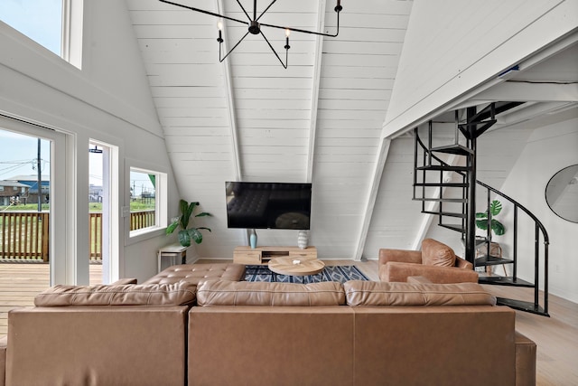 811 Seashell Dr, Surfside Beach, TX 77541 - living area with lofted ceiling, stairs, an inviting chandelier, and wood finished floors