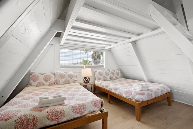 bedroom featuring vaulted ceiling with beams and wood finished floors