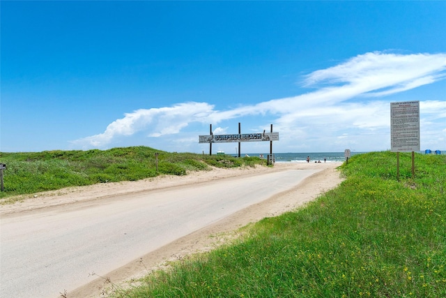 view of road with a water view and a view of the beach