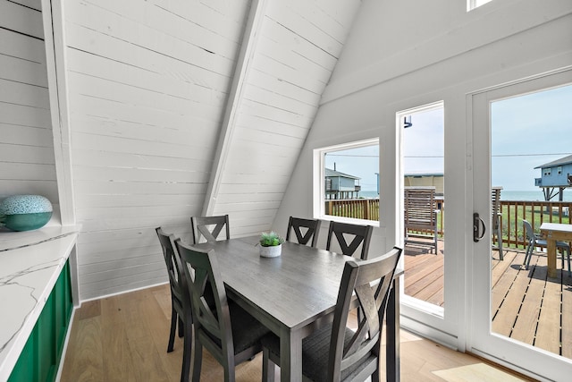 dining area with lofted ceiling and light wood finished floors