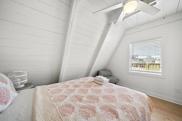 bedroom with baseboards, lofted ceiling with beams, ceiling fan, and wood finished floors