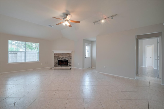 unfurnished living room with ceiling fan, rail lighting, vaulted ceiling, and light tile patterned floors