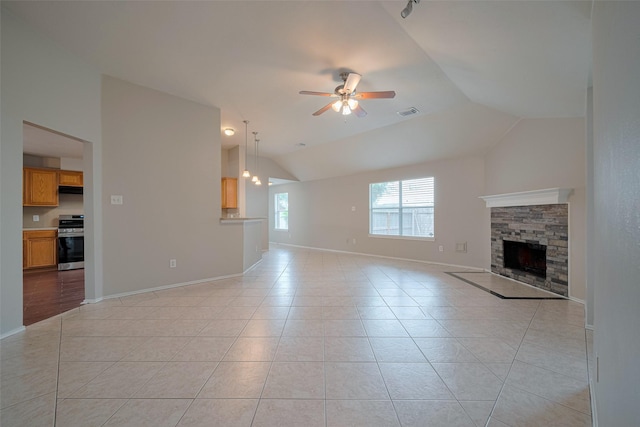 unfurnished living room with ceiling fan, a fireplace, baseboards, light tile patterned floors, and vaulted ceiling