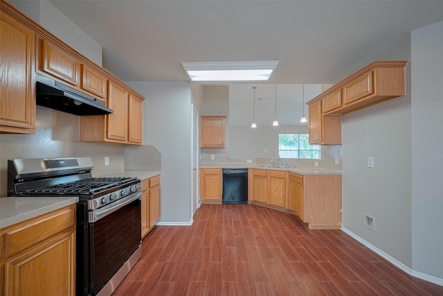 kitchen featuring wood finished floors, under cabinet range hood, stainless steel range with gas stovetop, a sink, and dishwasher
