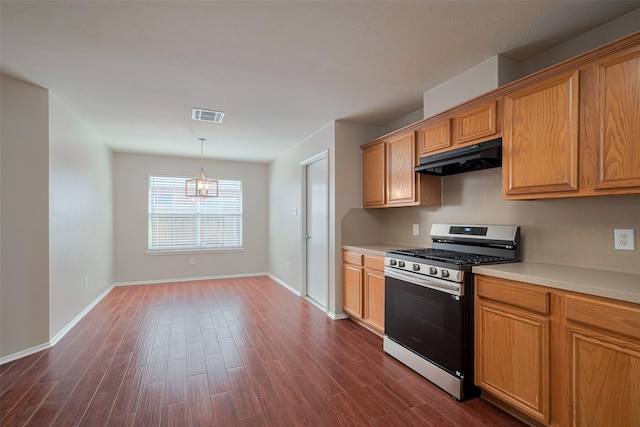 kitchen featuring visible vents, dark wood-style flooring, under cabinet range hood, and gas stove