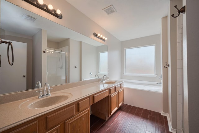 bathroom featuring visible vents, a sink, and a stall shower