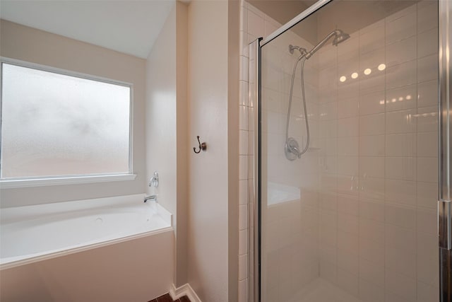bathroom featuring a shower stall and a bath