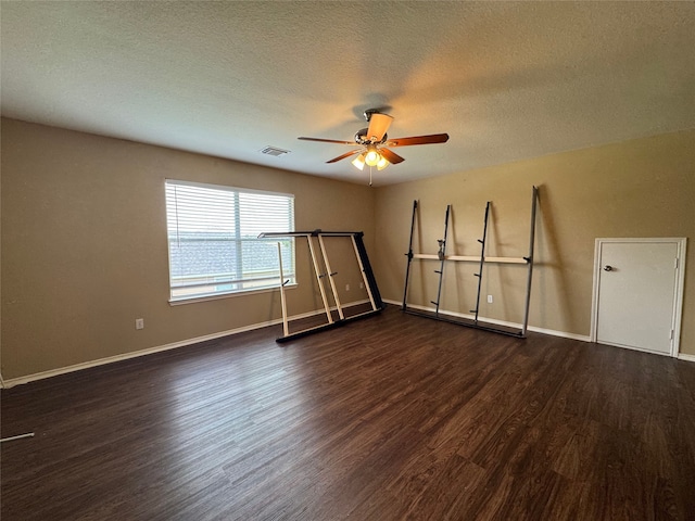 empty room with baseboards, a textured ceiling, ceiling fan, and wood finished floors