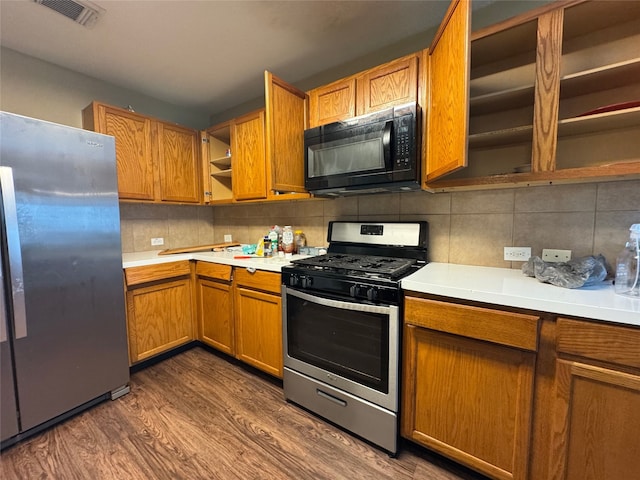kitchen featuring visible vents, open shelves, dark wood finished floors, light countertops, and stainless steel appliances