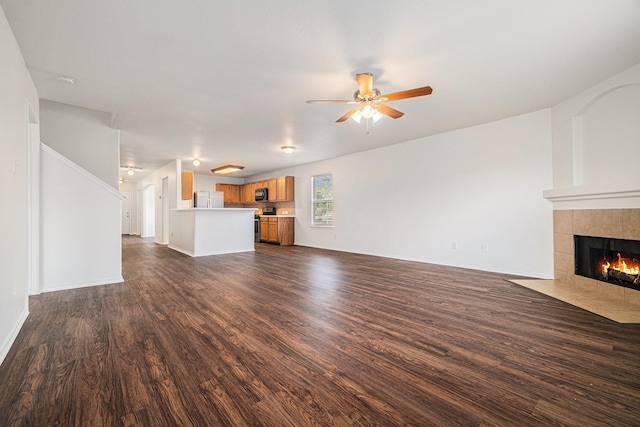 9607 Western Briar Ln, Humble, TX 77396 - unfurnished living room with a tiled fireplace, dark wood-style floors, and a ceiling fan