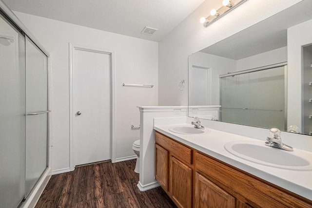 9607 Western Briar Ln, Humble, TX 77396 - full bathroom featuring wood finished floors, a shower with shower door, and double vanity