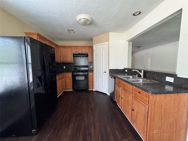 kitchen with visible vents, dark wood finished floors, a sink, black appliances, and under cabinet range hood