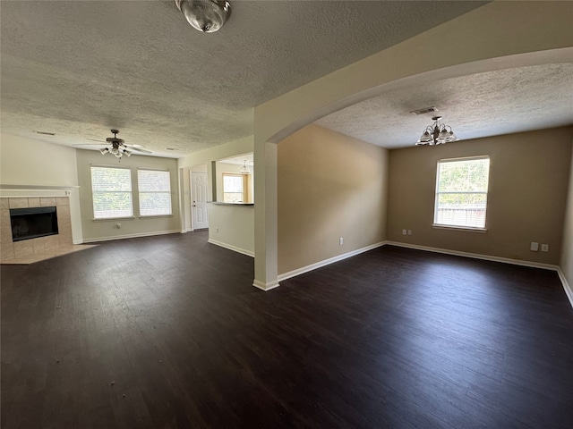 unfurnished living room with dark wood-type flooring, a textured ceiling, and a wealth of natural light