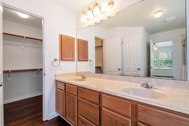 900 Summer Wood Blvd, Conroe, TX 77303 - bathroom with wood finished floors, double vanity, a walk in closet, baseboards, and ceiling fan
