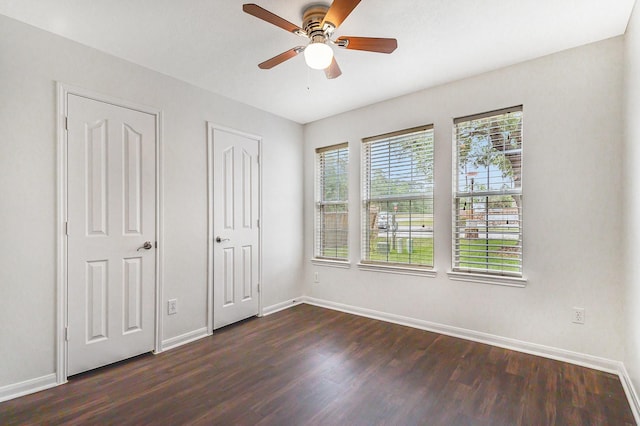 900 Summer Wood Blvd, Conroe, TX 77303 - unfurnished bedroom featuring dark wood finished floors, baseboards, and a ceiling fan