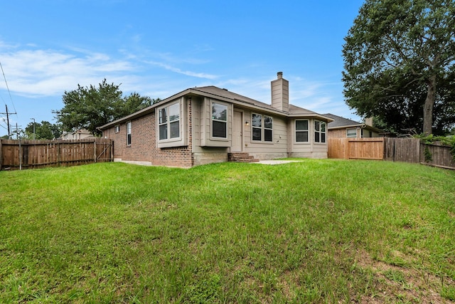900 Summer Wood Blvd, Conroe, TX 77303 - back of property with a chimney, entry steps, and brick siding
