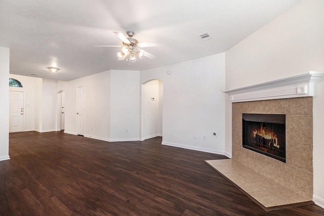 900 Summer Wood Blvd, Conroe, TX 77303 - unfurnished living room with arched walkways, a ceiling fan, wood finished floors, baseboards, and a fireplace