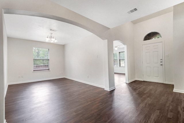 900 Summer Wood Blvd, Conroe, TX 77303 - foyer entrance with dark wood finished floors, arched walkways, a chandelier, and baseboards