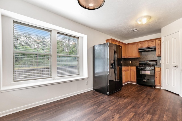 900 Summer Wood Blvd, Conroe, TX 77303 - kitchen with black appliances, under cabinet range hood, dark wood-type flooring, baseboards, and backsplash