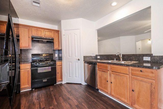 900 Summer Wood Blvd, Conroe, TX 77303 - kitchen featuring black appliances, under cabinet range hood, a sink, dark wood-style flooring, and arched walkways