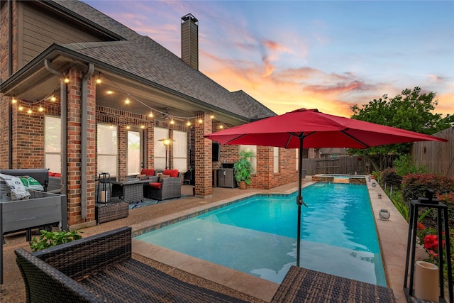 20687 Lavone Dr, Porter, TX 77365 - pool at dusk featuring outdoor lounge area, a fenced backyard, a patio area, and a pool with connected hot tub